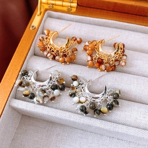 Detailed close-up of vintage beaded tassel hoop earrings inside a gray velvet jewelry box