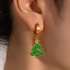Close-up of a festive green Christmas tree drop earring with golden hoop on a model's ear