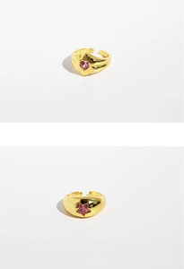 Detailed macro view of gold signet rings featuring pink heart and star zircon gemstones