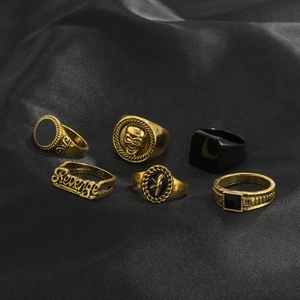 Detail shot of 6-piece vintage punk ring set with skull and crystal on black silk