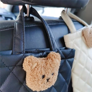 Car back seat organizer in quilted leather featuring a cute plush bear decoration
