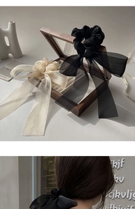 Detail of elegant black and cream organza bow hair clip for French style updos