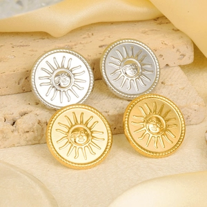 Detailed view of sun face stud earrings in gold and silver plating on silk background