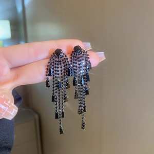 Detailed view of long black rhinestone tassel earrings with a tiered fringe design