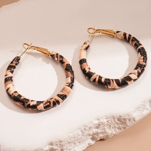 Detail of leopard print leather wrapped hoop earrings with gold plated vintage finish