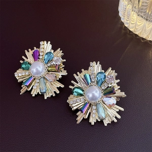 Macro detail of French vintage earrings with colored crystals, pearls and gold finish