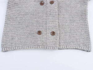 Detail of grey waffle knit cardigan with double-breasted buttons and ribbed hem