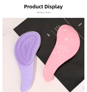 Detail showing two ergonomic hairbrushes in solid purple and pink marble pattern