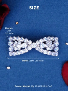 Detailed view of rhinestone bow hair clip with size dimensions on blue background