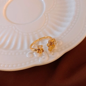 Detail of vintage golden rose ring with zircons on an elegant embossed porcelain plate