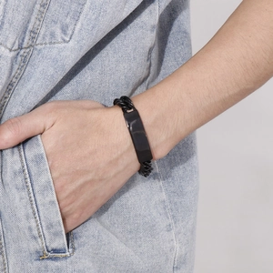 Dettaglio di un bracciale da uomo in acciaio inossidabile nero con piastra curva al polso