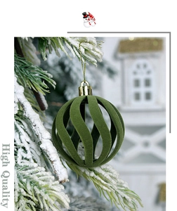 Macro shot of a green flocked Christmas ball with hollow stripes on snowy pine branch