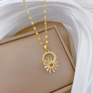 Detailed close-up of a gold flower necklace with crystal inlay on a beige jewelry box