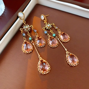 Macro detail of starburst crystal earrings with sparkling long champagne fringe