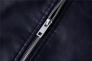 Close-up of silver metal zipper and precise double-stitch sewing on black leather jacket