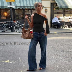 Détail du haut chic noir à une épaule avec un ruban asymétrique et design élégant