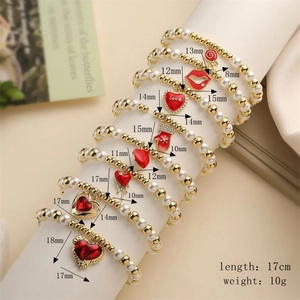 Detailed view of elastic pearl bracelets with red enamel heart and glove charms and specs