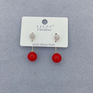 Detail view of long tassel earrings with S925 silver needles and glossy red pearl accents