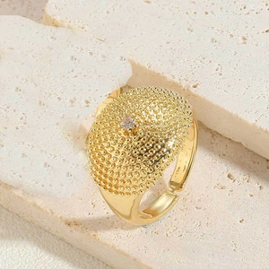 Macro shot of gold bohemian ring with textured metal beads and tiny central zircon stone