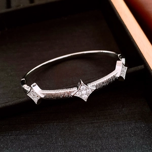Macro shot of silver textured bangle featuring three starburst patterns with zircon accents