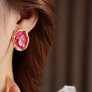 Detail of vintage whale earrings with red enamel and small white pearls on golden frame