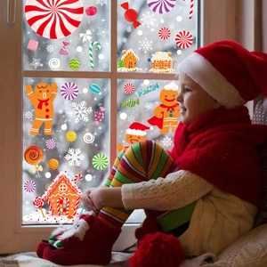 Christmas window decals with gingerbread man and candy cane on snowy glass background