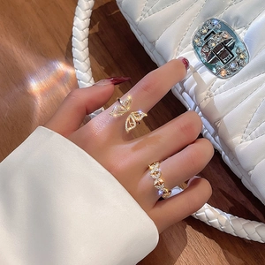 Detail of luxury gold butterfly and leaf open rings with diamonds on model finger