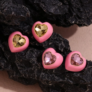 Détail macro de boucles d'oreilles en cœur avec émail rose et pierres précieuses lavande