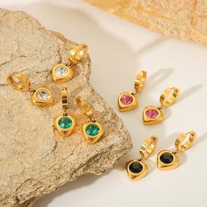 Close-up of 18K gold-plated heart earrings with multicolored zircon stones on stone