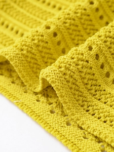 Close-up of yellow halter knit top showing detailed crochet texture and artisanal weave