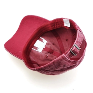 Detail view of burgundy washed cotton baseball cap interior with 100% cotton label