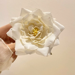 Elegant white silk artificial orchid flower hair claw clip shown in a hand