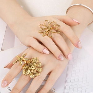 Detailed close-up of gold starfish and leaf rings worn by a model in a trendy setting