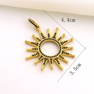 Macro shot of gold sun pendant with black stones measuring 4.4cm by 3.5cm for jewelry DIY