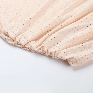 Macro de strass argentés haute densité sur un tissu rose doux avec des détails plissés