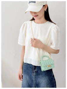 Detail of light green quilted jelly bag with pearl handle and pearl collar white top