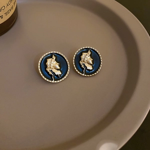Detailaufnahme der Vintage Gold-Ohrringe mit blauem Emaille-Porträt auf einem Tablett