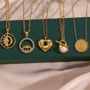Five 18K gold plated stainless steel necklaces with evil eye and heart charms on silk