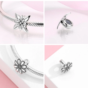Macro detail of S925 sterling silver daisy and star spacer beads for charm bracelets