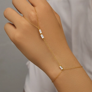 Detail of s925 silver gold hand chain with three rectangular white zircon stones on skin