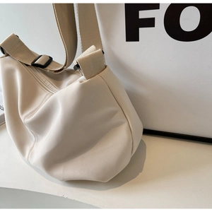 Detail shot of beige nylon tote bag showing durable fabric texture and adjustable strap