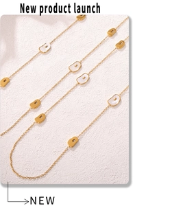 Macro detail of gold long chain necklace featuring white seashell inlaid bean pendants