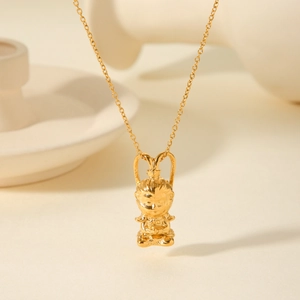 Artistic close-up of golden Wukong pendant necklace on a warm minimalist display stand