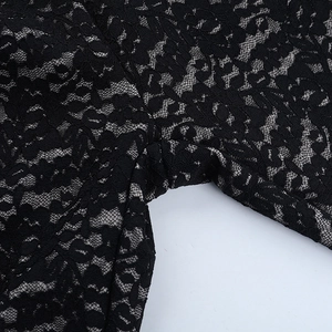 Macro view of intricate black lace texture and hollow patterns on the sexy bodysuit