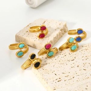 Close-up of assorted oval natural stones on gold-plated textured stainless steel rings