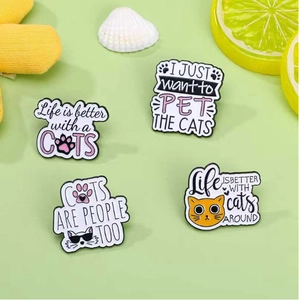 Detail of colorful cat enamel pins with funny slogans on fresh green background