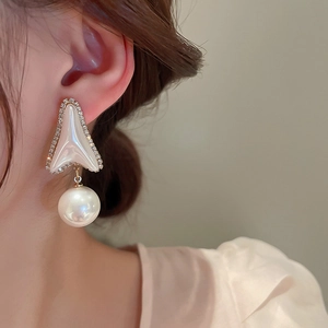 Dettaglio ravvicinato di orecchini con perle e strass e design geometrico su modella
