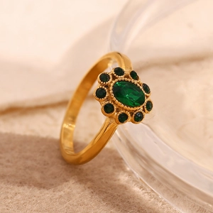Macro detail of vintage gold-plated ring with emerald sunflower design and sparkling crystals