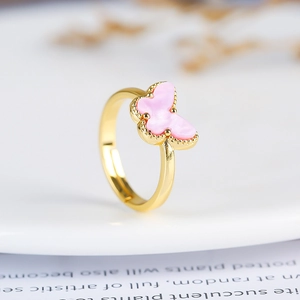 Macro shot of a minimalist gold ring with a delicate pink butterfly design for women