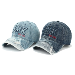 Détail des bords en jean effilochés et broderie SMK 3D sur les casquettes vintage